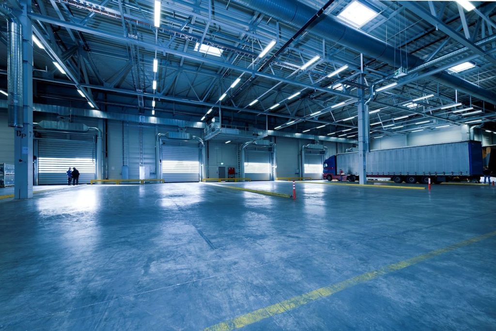 pexels-photo-221047 Large warehouse interior with docked truck, ideal for logistics and warehousing.